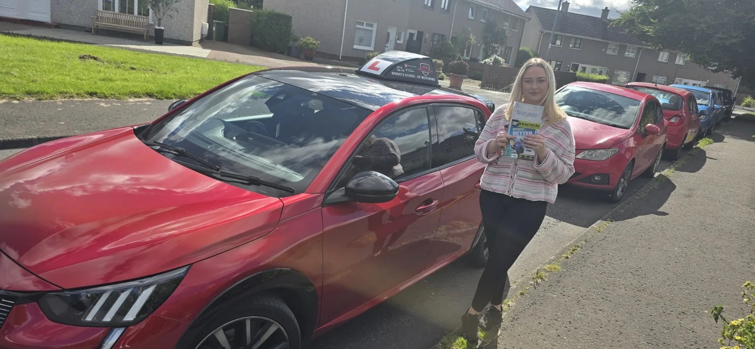 Successful Bravo's pupil beside red learner car